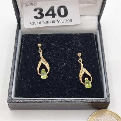 340 - An attractive pair of pear shaped 9 carat gold drop stud earrings, with green peridot stones.