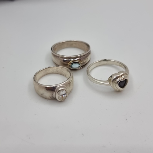 342 - A collection of three sterling silver rings (stamped 925) with zircon, garnet and aquamarine stones.... 