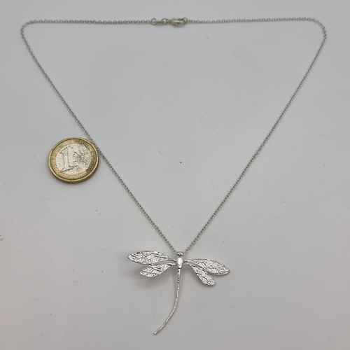 353 - A sterling silver (stamped 925) dragonfly pendant and chain. In bright cut finish. Length of chain 4... 