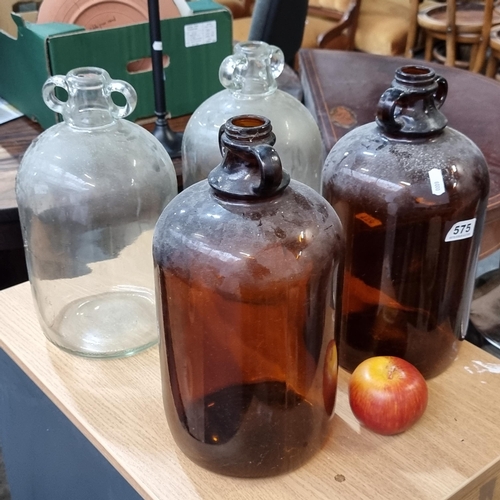 575 - Four large antique glass gallon bottles.