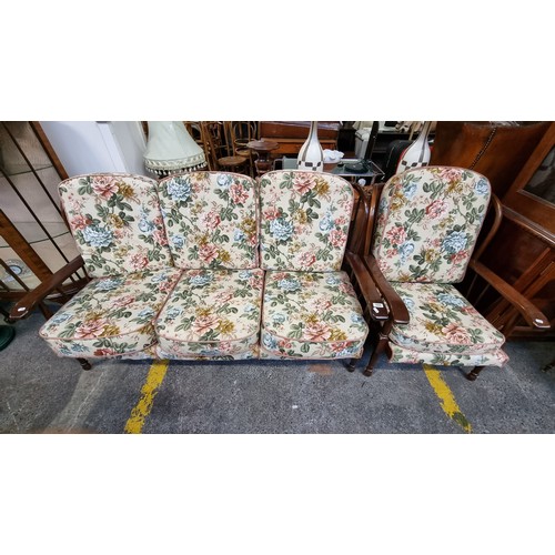 556 - Star Lot : A three seater spindle backed sofa with matching armchair. The floral upholstery is in go... 