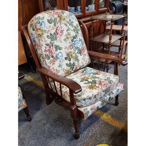 556 - Star Lot : A three seater spindle backed sofa with matching armchair. The floral upholstery is in go... 