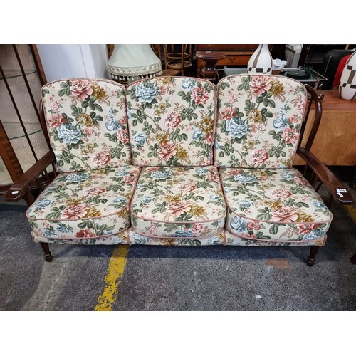 556 - Star Lot : A three seater spindle backed sofa with matching armchair. The floral upholstery is in go... 