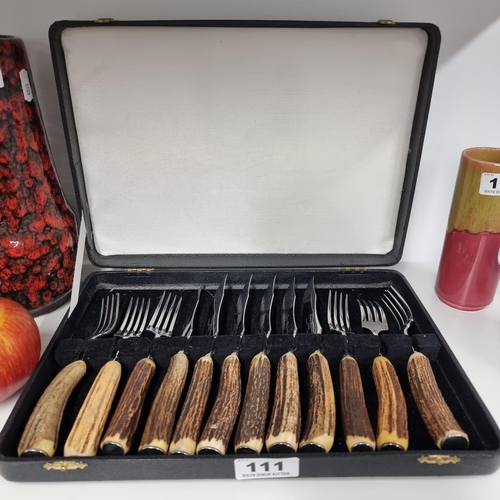111 - A vintage set of Brucut cutlery comprising of six pairs of steak knives and forks with stag antler h... 