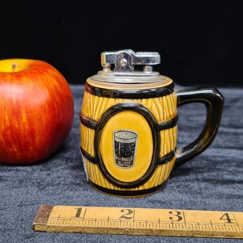 215 - A vintage Guinness branded ceramic desk top lighter in the shape of a barrel featuring a pint of Gui... 