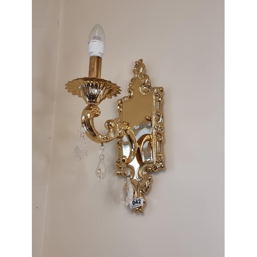 42 - A pair of single branch brass Italian wall sconces. Both featuring three leaf shaped drop crystals. ... 