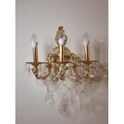 44 - Two three-branch brass toned wall sconces with crystal leaf pendants and lovely organic foliate carv... 