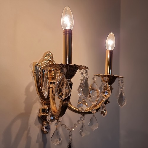 2 - A pair of Italian opulent brass two-branch wall sconces adorned with leaf-drop crystals in beautiful... 