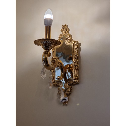 42 - A pair of single branch brass Italian wall sconces. Both featuring three leaf shaped drop crystals. ... 