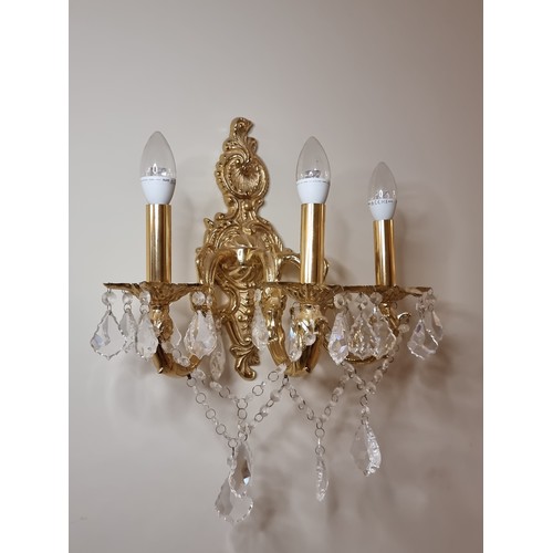 44 - Two three-branch brass toned wall sconces with crystal leaf pendants and lovely organic foliate carv... 