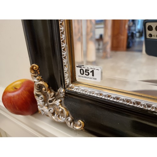 51 - A very large, contemporary bevelled mirror with a black frame with silver cresting detail. Gallery l... 