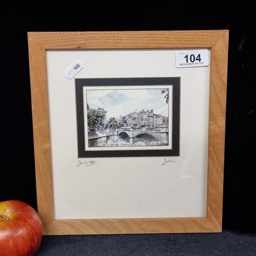 104 - A framed print of a painting showing O'Connell Bridge Dublin signed by the artist David Cotter. An i... 