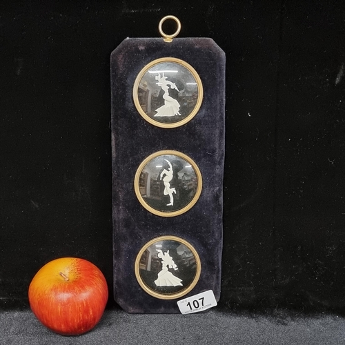 107 - A vintage black silk velvet wall hanging inset with three vignettes with concave glass windows featu... 