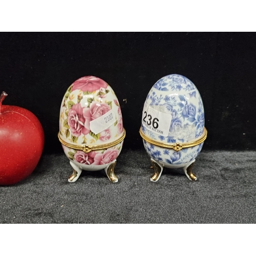 236 - Two neat sized decorative eggs, one with soft violet and blue floral design and one with deep pink r... 