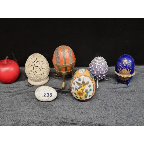 238 - 6 decorative eggs including one white marble example, a brass egg which opens for storage on a tripo... 