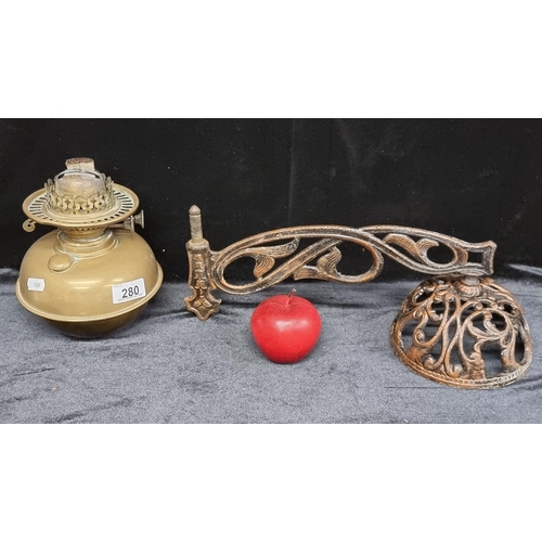 280 - A Victorian brass oil lamp base with a metal wall sconce. The oil lamp fits perfectly into this brac... 