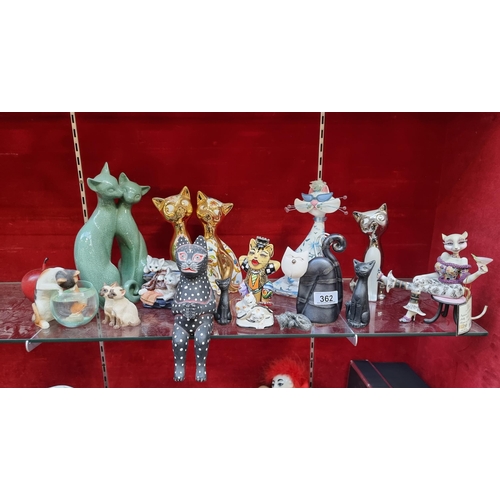 362 - A collection of sixteen feline figurines. Including a cat sipping cocktail, two sets of Siamese cats... 