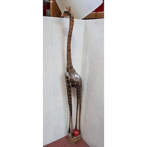 372 - A handcarved, vintage, huge wooden Giraffe figure measuring 130cm in height. Loss to ear.
