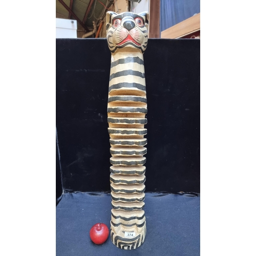 374 - A Balinese Tiger CD rack with handpainted details and carved from a single piece of wood. H80cm.