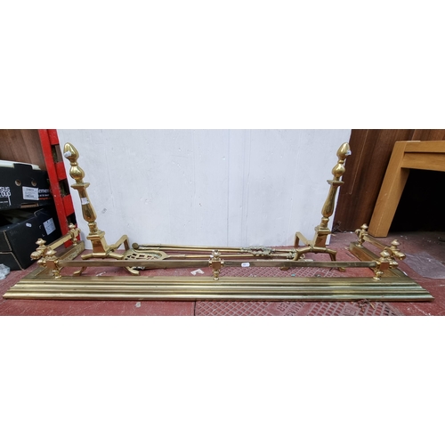 377 - 7 brass fireside items including a fire fender (Interior length 124cm) with a pair of large fire dog... 