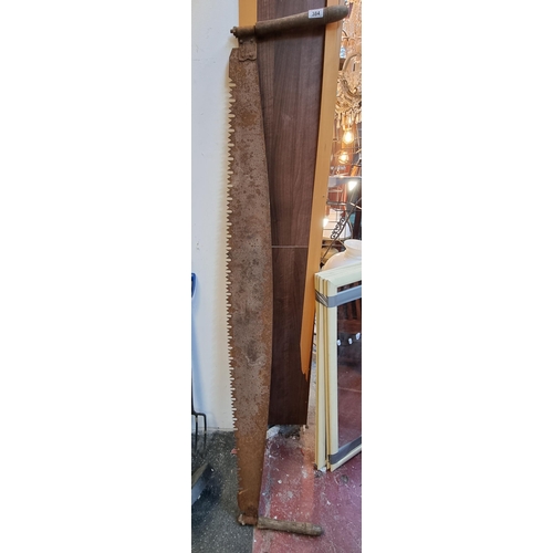 384 - An antique Two-Man Saw with heavy oak handles. Both handles are intact.