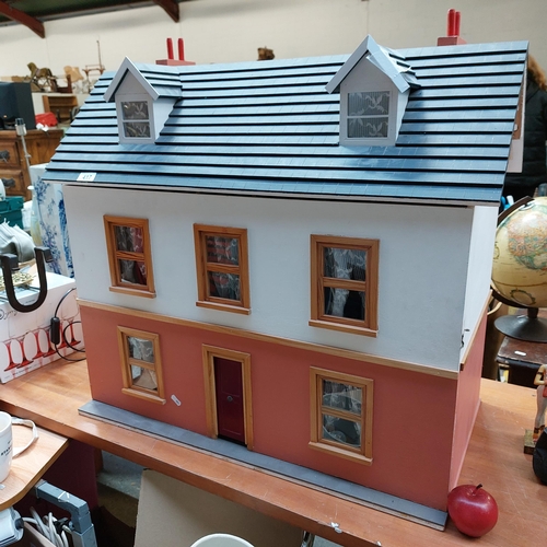417 - A beautiful wooden doll's house painted in shades of cream and terracotta. The home includes, a hing... 