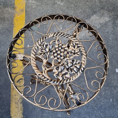 421 - A gold brushed wrought iron side table with a grape motif at the top. Mm: 70cm tall