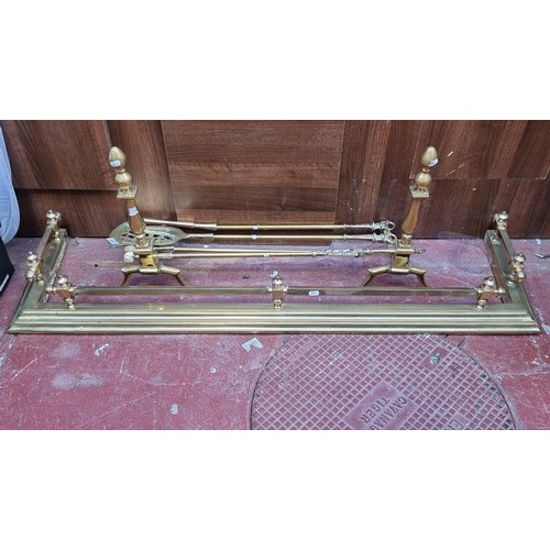 377 - 7 brass fireside items including a fire fender (Interior length 124cm) with a pair of large fire dog... 