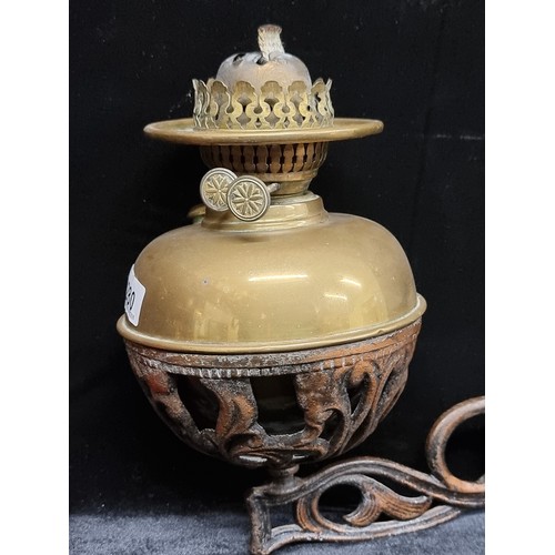 280 - A Victorian brass oil lamp base with a metal wall sconce. The oil lamp fits perfectly into this brac... 