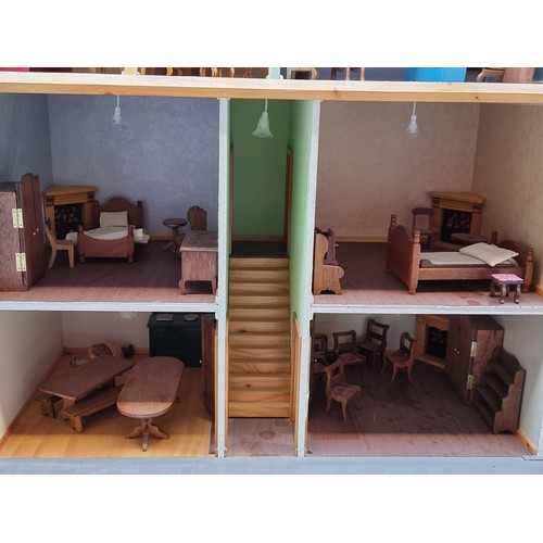 417 - A beautiful wooden doll's house painted in shades of cream and terracotta. The home includes, a hing... 