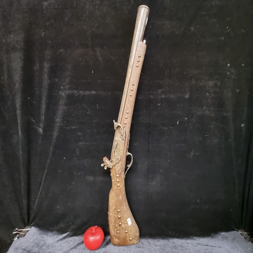 196 - A heavy wooden and brass Flintlock Blunderbuss with a short, large caliber barrel which is flared at... 