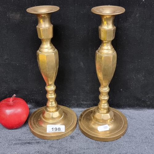 198 - A pair of antique English heavy brass octagonal cut candlesticks. Made in England to base.