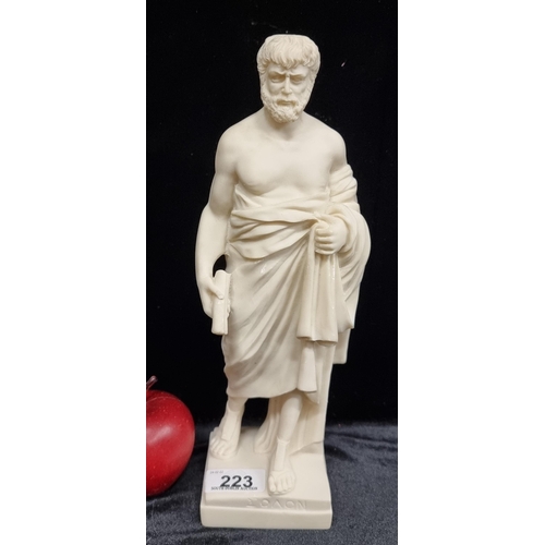 223 - A detailed handmade alabaster figure of Aristotle in a traditional Greek tunic and holding two scrol... 