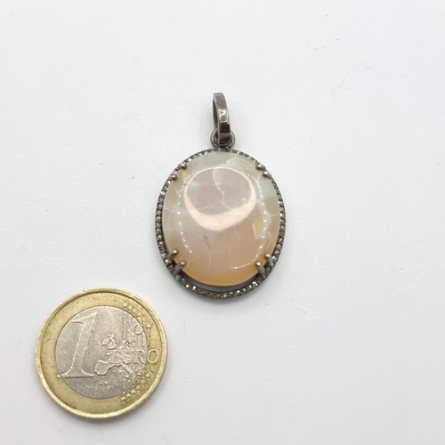22 - An attractive oval shaped pink ruby moonstone set pendant with pretty diamond surround. Very nice pi... 