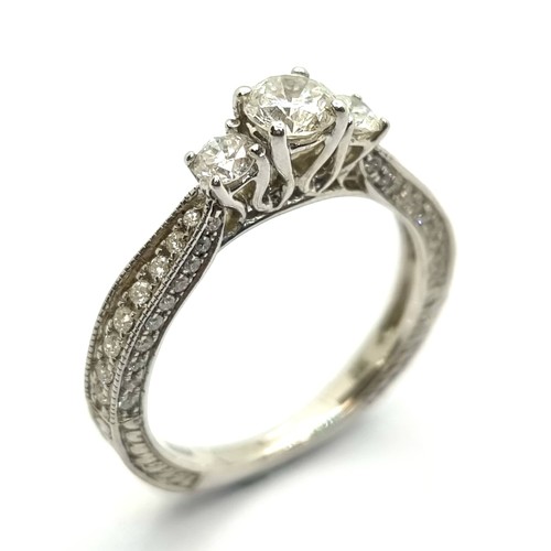 3 - Star Lot: An extremely fine example of a three stone diamond ring with diamond set shoulders. Total ... 