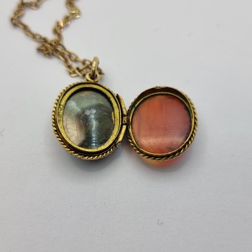 37 - An attractive pendant locket with gold toned chain. Locket set with tigers eye and tourmaline. Lengt... 