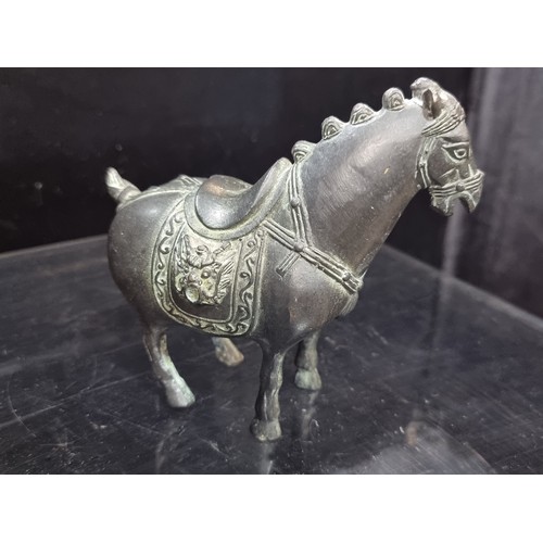555 - An early 20th century Chinese hand engraved cast heavy bronze horse statuette with lion head saddle.... 