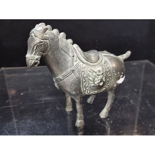555 - An early 20th century Chinese hand engraved cast heavy bronze horse statuette with lion head saddle.... 