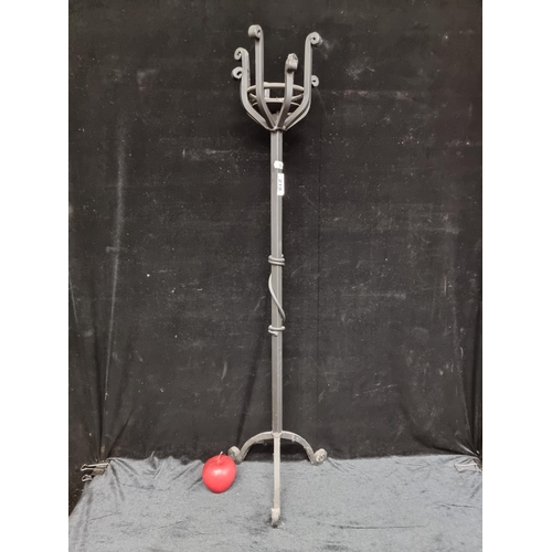 219 - A heavy cast metal pillar tall candle stand with scroll feet and matte black finish