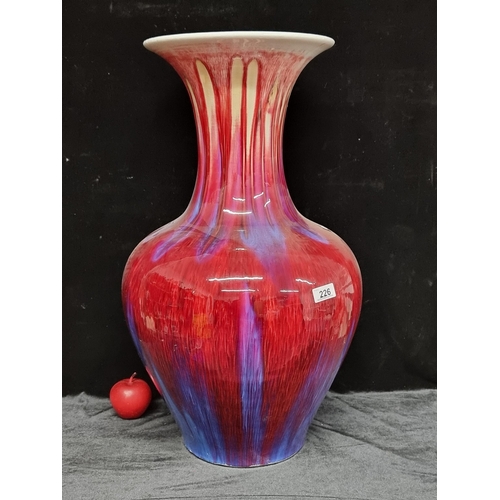 226 - A Huge Flambé glazed phoenix tailed vase. In striking shades of red, purple and yellow. 65 cm tall. ... 