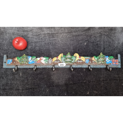 298 - A heavy cast metal 6 hook coat rack, hand painted with festive scenes of Christmas trees, toys and c... 