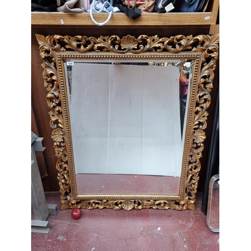 304 - A very large bevelled mirror with an elaborate Baroque style gilt frame. Mm: 105cm x 125cm