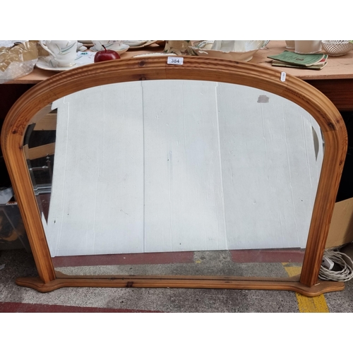 384 - A large over-mantle mirror with a wooden frame and bevelled glass. L120cm x H81cm