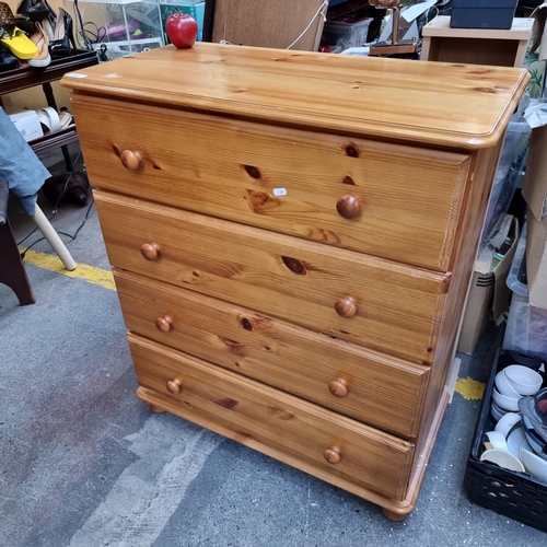 385 - A large pine wood chest of drawers. With four drawers and bun feet. H94cm x L80cm x D40cm