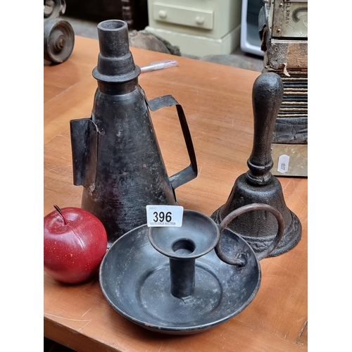 396 - Three vintage items, including a heavy cast metal bell and a black metal chamber candle stick holder... 