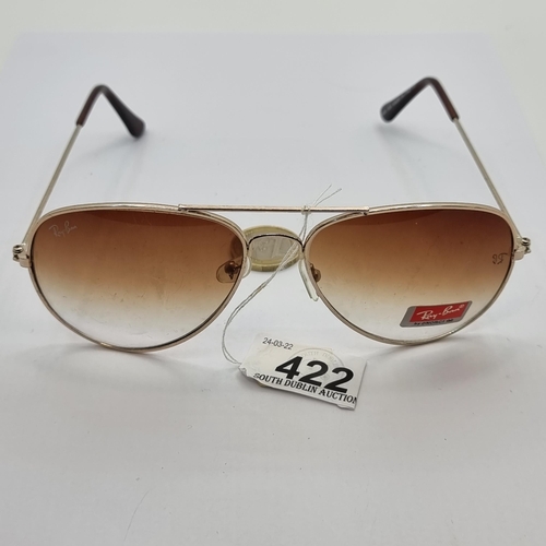 422 - A pair of new Ray Ban sunglasses. Good, clean example with gold toned rim and stems.