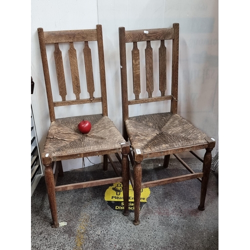 517 - Two antique wooden chairs with slat backs and sugan seats and turned front legs.