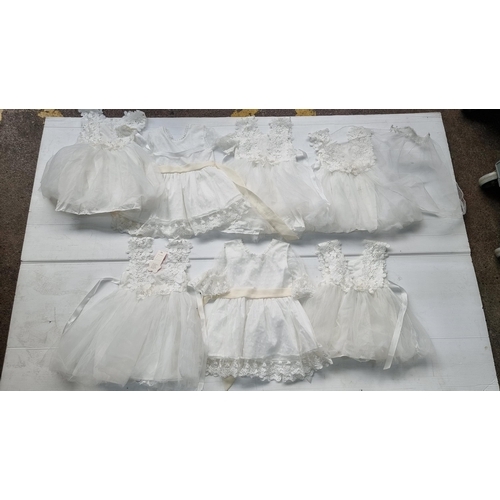 608 - A collection of seven brand new white  dresses for children aged 6 mths to 2 yrs. With lovely exampl... 