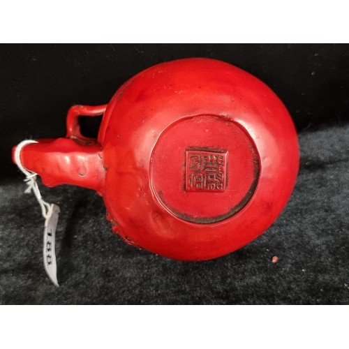 188 - A charming 19th century red cinnabar teapot with a whimsical design of bats and a handle in the form... 