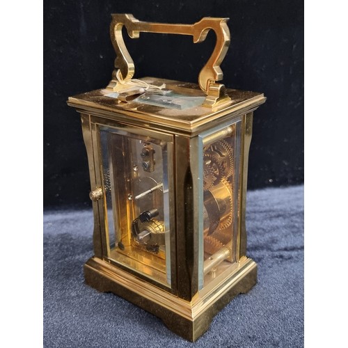 241 - A heavy brass antique carriage clock by David Peterson with bevelled glass. With  exposed fly wheel ... 